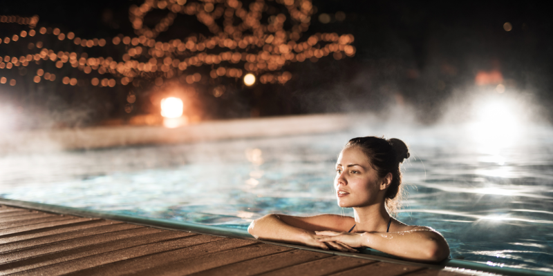 Customer enjoying a night swim after pool heater installation in Goodyear, AZ